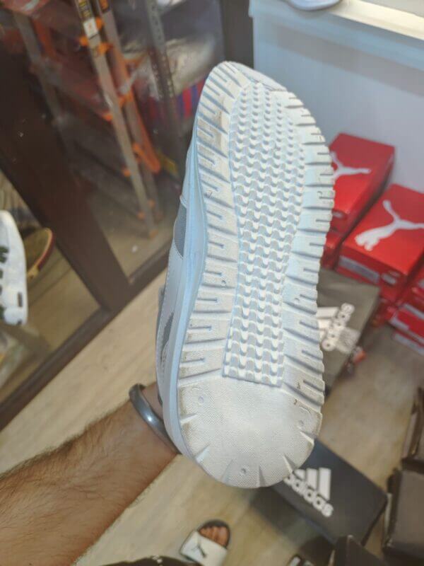 premium adidas shoe in my hand to demonstrate feet size